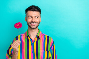 Photo of cheerful person toothy smile arm hold flower look empty space isolated on teal color...