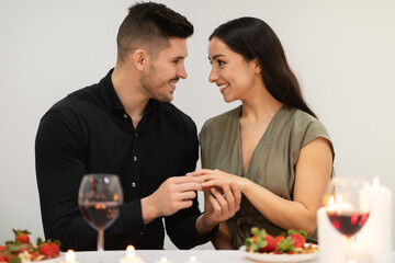 Loving beautiful young couple getting engaged while celebrating Valentine Day
