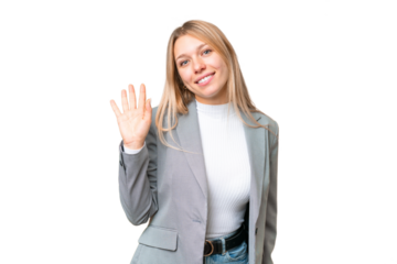 Young pretty blonde woman over isolated chroma key background saluting with hand with happy expression