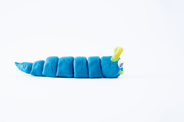plasticine play dough wriggly worm in blue and yellow isolated on a white background with copy space
