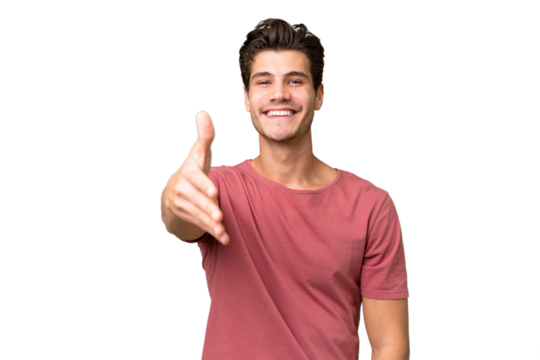 Young handsome caucasian man over isolated background shaking hands for closing a good deal