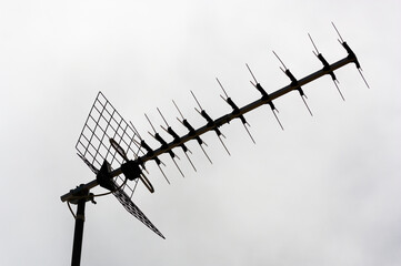Close-up of a terrestrial digital tv antenna against the backlight of the cloudy sky