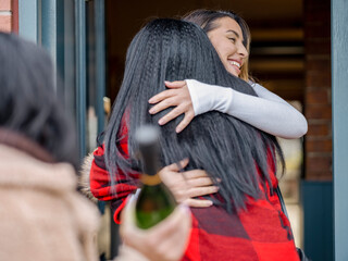 Women greeting at door while visiting friend in house © Cultura Creative