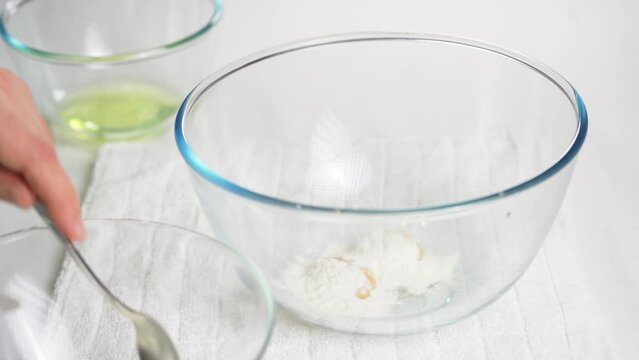Pour a tablespoon of flour into a transparent bowl with eggs to prepare the dough. High quality 4k footage