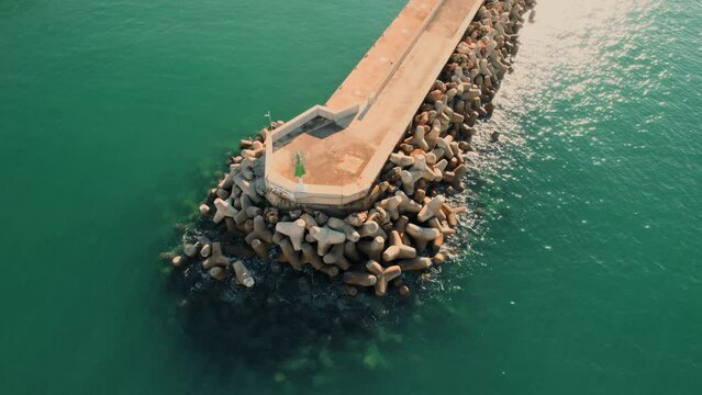 Aerial shot, drone point of view breakwaters surrounded by green waters of Mediterranean Sea of Santa Ponsa, small town in the southwest of Mallorca. Baleares, Spain
