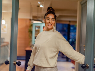 Portrait of smiling woman standing in doors at home
