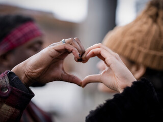 Close-up of couple making heart hand sign