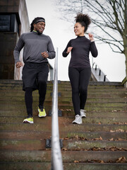 Athletic man and woman walking down steps outdoors