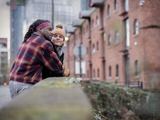 Smiling couple embracing on bridge