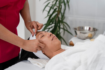 Woman having face massage at spa