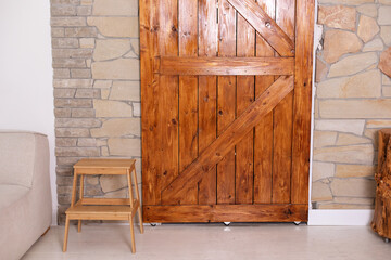 Obraz na płótnie Canvas Sliding barn wooden door in indoors. Sliding old Barn Door in modern room. Rustic farm wood sliding barn style door at home. 