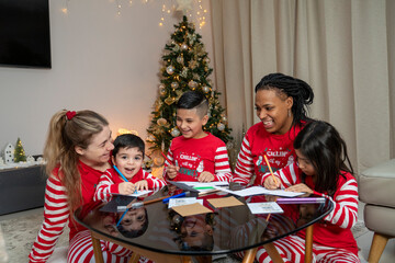 Moms with kids preparing Christmas cards at home