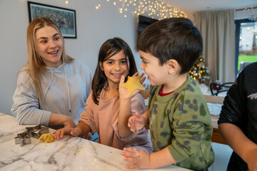 Mom with kids preparing Christmas cookies in kitchen