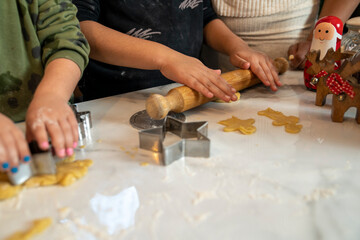 Mom with kids preparing Christmas cookies in kitchen