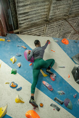Obraz na płótnie Canvas Rear view of athletic woman on climbing wall at gym