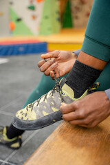 Close-up of woman tying climbing shoe at gym