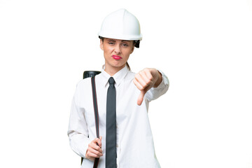 Young architect woman with helmet and holding blueprints over isolated background showing thumb down with negative expression
