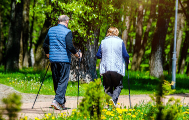 An elderly couple walks in the park
