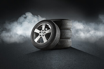 Car tires with a great profile on illuminates asphalt, smoke