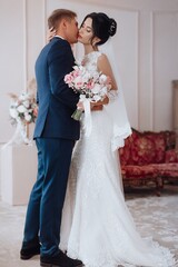 Beautiful young couple, the bride and groom. Luxurious light interior