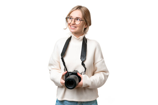 Young photographer English woman over isolated background looking up while smiling