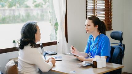 Obraz premium Asian Doctor and patient discussing something while sitting at the table . Medicine and health care concept. .