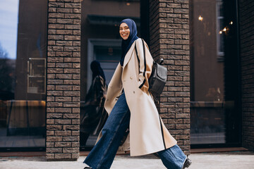 Young muslim woman student walking in the street