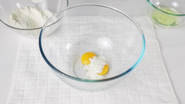 Pour a tablespoon of flour into a transparent bowl with eggs to prepare the dough. High quality 4k footage