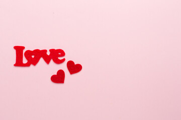 Felt word love with hearts on color background, top view