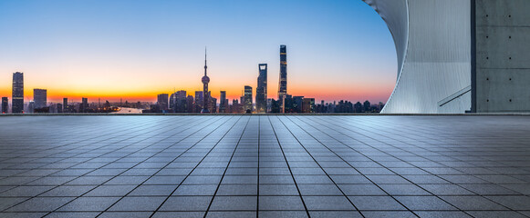 Empty square floor and city skyline with modern building at sunrise in Shanghai, China.