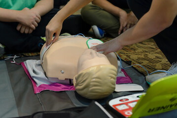 First aid cardiopulmonary resuscitation course using automated external defibrillator device - AED training. selective focus placing electrode.