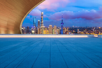 Empty square floor and city skyline with modern building at night in Shanghai, China.