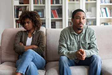 Obraz premium Sad black man and woman sitting on couch at home