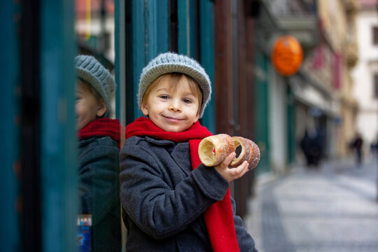 Child in Prague, eating traditional czech dessert trdelnik