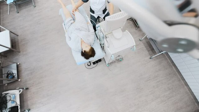 doctor does an ultrasound of the veins on the patient's legs. A phlebologist checks the veins on a woman's legs with an ultrasound machine in a modern clinic.