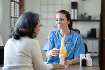 Specialist female doctor Explaining knee precautions and methods of treating the symptoms of elderly female patients.