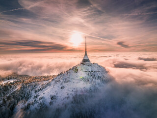 Jested tower mountain hill with snow mist and fog at golden hour