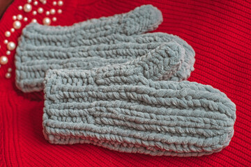 Fototapeta na wymiar Warm grey knitted gloves. Fashionable collection of accessories for women. Detail of wardrobe