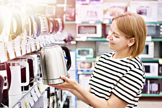Woman with electric kettle in shop