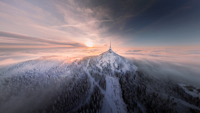 Jested tower mountain hill with snow mist and fog at golden hour