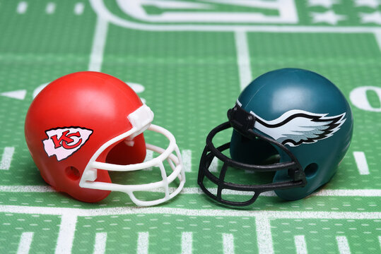 IRVINE, CALIFORNIA - 30 Jan 2023: Football helmets of the Kansas City Chiefs vs Philadelphia Eagles, opponents in Superbowl LVII, on a gridiron background.