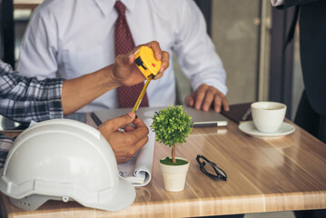 Asian engineer man brainstorming teams partner meeting office desk on construction site. Engineering men building contractor civil worker team meeting together. Men look at construction Blueprint