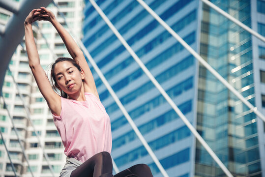 Sport Fitness Woman Stretching Body Exercise In Modern City Wear Wellness Sportswear Outside. Young Woman Workout Outdoor Exercising On Bright Sunny Outside. Healthy Wellness Lifestyle Woman Concept.