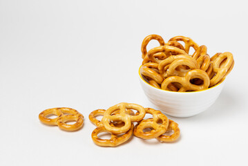 Salty pretzels in a white bowl isolated. Salted snacks or crackers on a white background