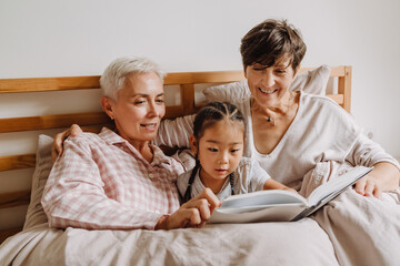 Happy mature same sex couple with adopted asian little girl