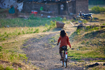 Indian teenage girl is riding an old bicycle at Indian Village