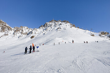 Fototapeta na wymiar Skiers and snowboarders on the top station of Courchevel and Meribel slopes, France.