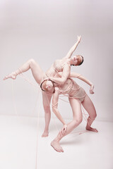 Blind following. Portrait of two young girls posing in underwear and ropes with eyes closed over...