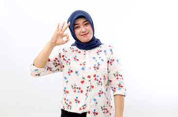 Fototapeta premium Happy asian muslim woman standing while showing okay hand gesture. Isolated on white background