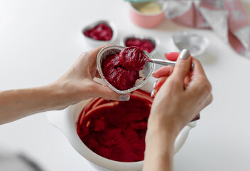 woman cooking cupcakes for valentines day. Delicious heart shaped red velvet cupcakes. closeup